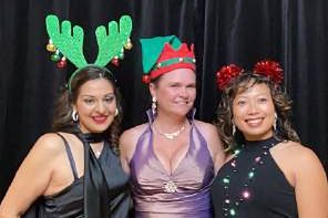 Three guests in antlers and elf hats at a photo booth, photographed by Dario Hudon