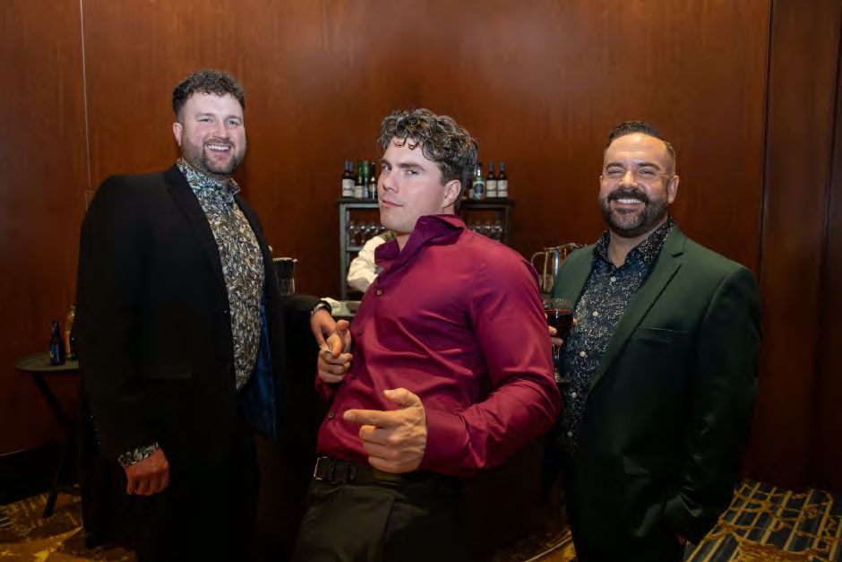 Three guests sharing a joke at a company holiday party, photographed by Dario Hudon