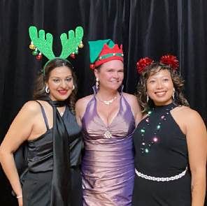 Three guests in antlers and elf hats at a photo booth, photographed by Dario Hudon