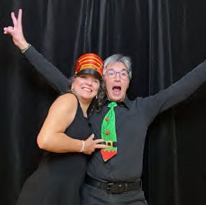 Two guests celebrating with their arms raised at a photo booth, photographed by Dario Hudon