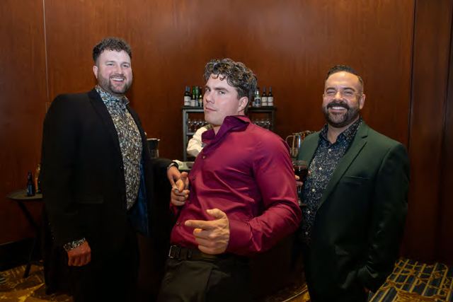 Three guests sharing a joke at a company holiday party, photographed by Dario Hudon