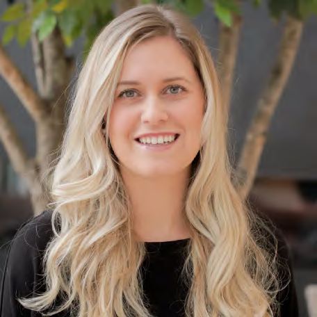 A headshot of a smiling woman with long blonde hair, photographed by Dario Hudon